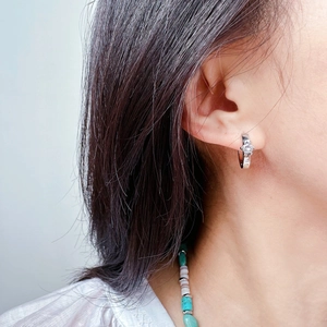 Classic silver hoop earring with sparkling round zircon stone in 4-prong setting on ear