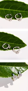 Detail of silver hoop earrings with a single round zircon in a six-prong setting