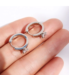 Detailed hand-held view of a silver hoop earring featuring a brilliant round cubic zirconia