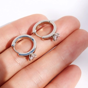 Classic silver hoops with single round zircon stones held between fingers for scale