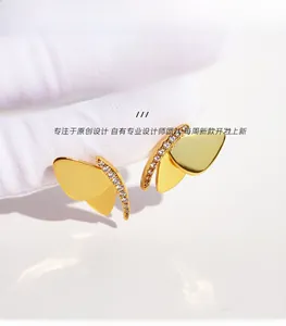 Detailansicht goldener Schmetterlingsstecker mit funkelnden Zirkonia-Steinen