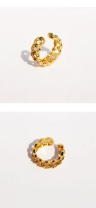 Detail of vintage gold lace ring with emerald green zircon accents and hollow pattern