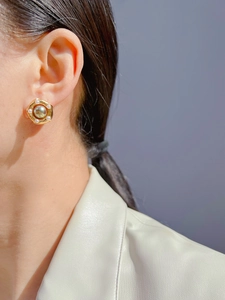 Macro shot of vintage French pearl earrings with hexagonal gold-plated textured base