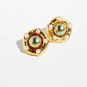 French vintage brass gold earrings with iridescent green pearl and radial relief design