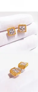 Gros plan de boucles d'oreilles carrées en zircon avec filigrane d'or et bords perlés