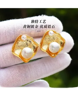 Macro di orecchini irregolari in ottone placcato oro con perle bianche lucide