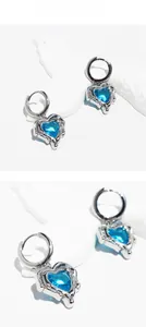 Macro detail of liquid lava heart earrings featuring ocean blue zircon and silver metal