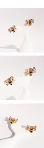 Detail presentation of handmade bee earrings with zircon wings and yellow enamel body