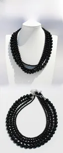 Detail of multi-layer black beaded necklace with metallic lobster clasp and adjustable chain