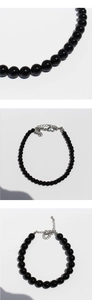 Macro detail of elegant black onyx beaded bracelet with silver lobster clasp and chain