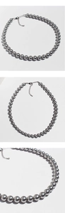 Dettaglio di collana con perle grigio scuro con chiusura a moschettone in argento e catena