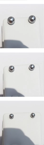 Dettaglio di orecchini con perle grigio argento su un supporto bianco con texture