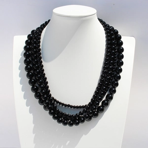 Elegant black onyx multi-layer beaded necklace on a white neck mannequin stand