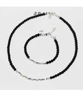Detail of black onyx beads necklace and bracelet set with silver-toned faceted metal accents