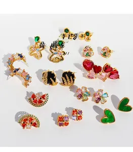 Detailed close-up of brass gold-plated earrings with colorful zircon floral and heart shapes
