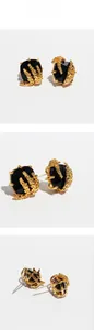 Detail of square black gemstone earrings with gold wheat ear carving in three perspectives
