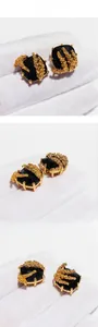 Close-up of vintage gold wheat ear design around a square black gemstone earring