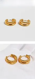 Macro view of gold-plated twisted rope hoop earrings with double-layered vintage design