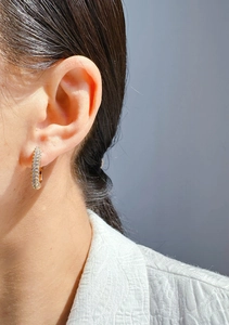 Macro detail of 24k gold plated U-shaped earrings with micro-pave crystals on model