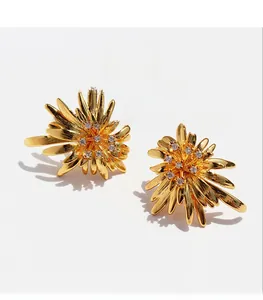 Macro shot of gold sun flower earrings featuring zircon flower core and fireworks petals