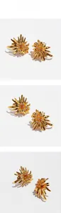 Macro detail of golden sunflower stud earrings with shimmering zircon center petals