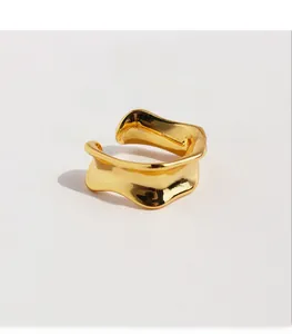 Detailed view of irregular wavy gold plated brass ring with sparkling zircon accents