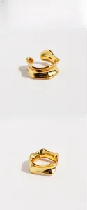 Detailed view of golden irregular folded ear cuff with lava texture and mirror finish