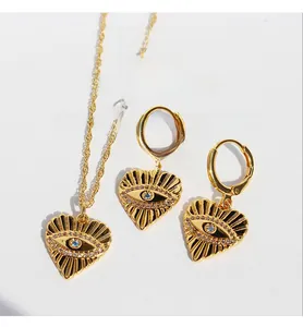 Vue détaillée de l'ensemble de bijoux en laiton doré avec cœurs et pendentifs mauvais œil