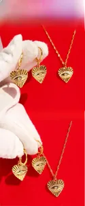 Gros plan sur l'ensemble bijoux cœur doré avec motifs en relief et cristaux d'œil bleus