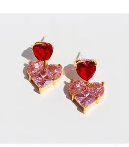Close-up of heart-shaped pink and red zircon drop earrings in gold-plated brass