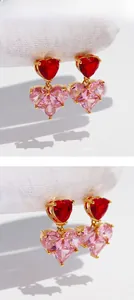 Macro detail of gold-plated double heart earrings with red and pink zircon crystals