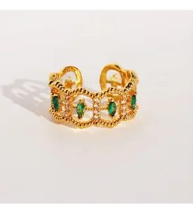 Detail of vintage gold-plated lace ring with emerald zircon and marquise-cut stones