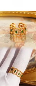 Detail of vintage gold-plated lace ring featuring marquise emerald green zircons