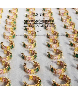 Detailed view of rainbow zircon C-shaped earrings with step-cut colorful gemstones
