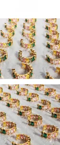 Detailed close-up of C-shaped gold-plated hoops with colorful square-cut zircon stones