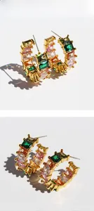 Detail shot of gold C-hoop earrings with colorful emerald-cut baguette cubic zirconia