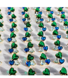Macro shot of heart-shaped blue zircon studs in gold-plated brass setting with clusters