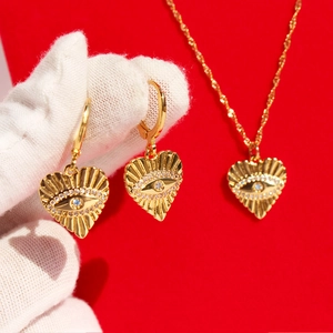 Parure de bijoux cœur doré avec pendentifs œil maléfique, texture radiale et zircons