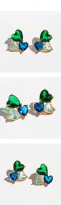 Detailed views of gold heart earrings with clustered blue and green zircon gemstones