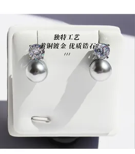 Close-up of premium zircon and grey round pearl on brass gold plated earring studs
