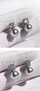 Macro shot of silver grey round pearls and sparkling cubic zirconia earrings on silver