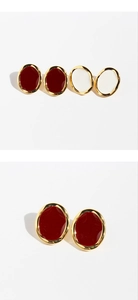Detailopname van de vintage ovale emaille oorbellen in rood en wit met goud metaal