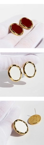 Detailweergave van retro bordeauxrode en witte emaille ovale oorbellen met goud metaal