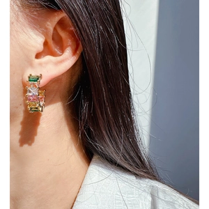 Rainbow cubic zirconia C-shape hoop earrings with emerald cut stones on a model
