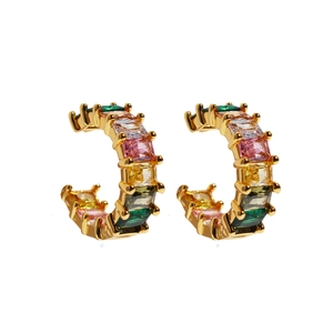 Golden C-shaped earrings with colorful emerald-cut gemstones in a rainbow palette