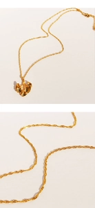 Dettaglio della collana con foglia di ginkgo dorata e catenina a maglia ritorta fine