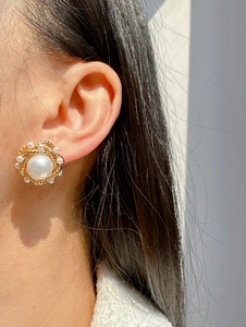 Close-up of vintage French pearl earrings with twisted gold border and mini pearl accents