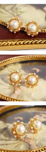 Macro view of vintage twisted gold pearl earrings with intricate beadwork details