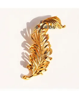 Detailed view of gold-plated feather brooch crafted from brass and high-quality zirconia