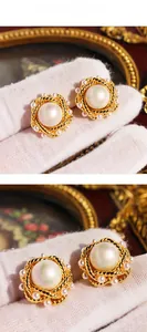 Detail showing vintage gold twisted edge earrings with large pearl and small studs